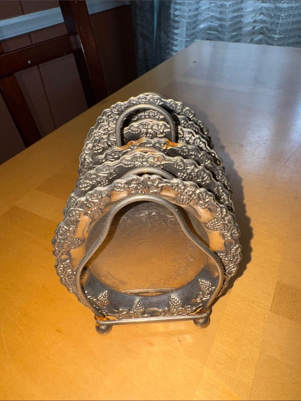 six vintage silver-plated drink coasters with ornate, embossed floral